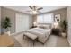 This is a staged bedroom with a neutral color scheme and features a large window for natural light at 10957 Keys Gate Dr, Riverview, FL 33579