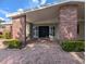 Home entrance featuring brick columns, a covered porch, and a well-maintained landscape at 3931 E Eden Roc Cir, Tampa, FL 33634