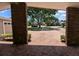 View from a covered entrance porch showing brick columns, a paved driveway, and a tree at 3931 E Eden Roc Cir, Tampa, FL 33634