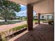 Charming covered front porch with brick columns, a swing, and manicured landscaping at 3931 E Eden Roc Cir, Tampa, FL 33634