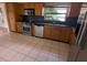 Kitchen with stainless steel appliances, black countertops, and light tile floor at 3931 E Eden Roc Cir, Tampa, FL 33634