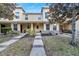 Exterior view of a tan townhome with a stone accent, front porch and landscaping at 10957 Keys Gate Dr, Riverview, FL 33579