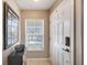 Bright entryway with white door, window blinds and a Beatles themed decor at 10957 Keys Gate Dr, Riverview, FL 33579