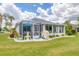 Landscaped backyard with a screened patio, grill, and fountain at 2128 W Del Webb Blvd, Sun City Center, FL 33573