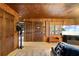 Cozy living room featuring wood paneling, large TV, and comfortable seating at 17501 Brown Rd, Odessa, FL 33556