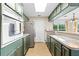 Galley kitchen with green cabinets and stainless steel appliances at 17501 Brown Rd, Odessa, FL 33556