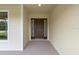 Front entry with brown door and sidelights, leading into the home at 9187 Prospect Ave, Englewood, FL 34224