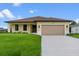 Exterior of a single-story home with a two-car garage and manicured lawn at 9187 Prospect Ave, Englewood, FL 34224