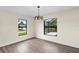 Dining room with wood-look floors and large windows overlooking the pool at 9187 Prospect Ave, Englewood, FL 34224