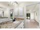 Bathroom with granite countertop, double vanity, and access to bedroom at 9187 Prospect Ave, Englewood, FL 34224