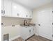 Laundry room with white cabinets, granite countertop, and a utility sink at 9187 Prospect Ave, Englewood, FL 34224