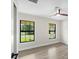 Well-lit bedroom featuring wood-look floors and two large windows at 9187 Prospect Ave, Englewood, FL 34224