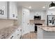 Modern kitchen with white cabinets, granite countertops and stainless steel appliances at 9187 Prospect Ave, Englewood, FL 34224