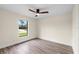 Simple bedroom with large window and wood-look floors at 9187 Prospect Ave, Englewood, FL 34224