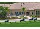 Community clubhouse with outdoor seating and golf cart parking at 8403 Grand Estuary Trl # 106, Bradenton, FL 34212