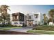 Modern two-story home featuring a manicured lawn, minimalist landscaping, and a unique architectural design at 4305 W Zelar St, Tampa, FL 33629