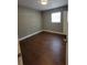 Cozy bedroom with wood-look floors, neutral walls, and white trim at 4305 E Deleuil Ave, Tampa, FL 33610