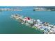 Aerial shot of waterfront homes with docks offering beautiful views of the water and skyline at 831 Bay Point Dr, Madeira Beach, FL 33708