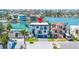 Aerial view of a modern waterfront home with well-manicured landscaping and a large driveway at 831 Bay Point Dr, Madeira Beach, FL 33708