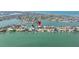 Wide aerial perspective showcasing waterfront homes with access to the bay and the distant city skyline at 831 Bay Point Dr, Madeira Beach, FL 33708