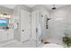 Bright bathroom featuring a glass shower, white marble tile, modern fixtures and a white paneled door at 831 Bay Point Dr, Madeira Beach, FL 33708