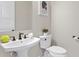 Elegant powder room featuring modern fixtures, pedestal sink, and toilet at 831 Bay Point Dr, Madeira Beach, FL 33708