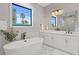 Modern bathroom with soaking tub, dual sinks, and marble tile in shower at 831 Bay Point Dr, Madeira Beach, FL 33708