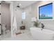 Modern bathroom with freestanding tub, glass shower, and marble tile at 831 Bay Point Dr, Madeira Beach, FL 33708
