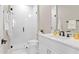 Modern bathroom featuring a glass-enclosed shower, white subway tiles, and a sleek white vanity with dark fixtures at 831 Bay Point Dr, Madeira Beach, FL 33708