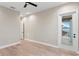 Bedroom has wood floors, ceiling fan and white trim door leading to balcony at 831 Bay Point Dr, Madeira Beach, FL 33708