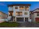 Front exterior of three-story home featuring two-car garage, staircase, and multiple balconies at 831 Bay Point Dr, Madeira Beach, FL 33708