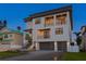Three-story modern home featuring a two-car garage, balconies, and staircase at 831 Bay Point Dr, Madeira Beach, FL 33708