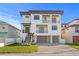 Beautiful modern home with a manicured lawn, gray three-car garage and stylish balconies at 831 Bay Point Dr, Madeira Beach, FL 33708