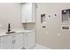 Bright laundry room features white cabinets, quartz countertops, and modern fixtures at 831 Bay Point Dr, Madeira Beach, FL 33708