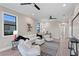 Bright living room with light floors, white furniture, and large windows bringing in natural light and water views at 831 Bay Point Dr, Madeira Beach, FL 33708