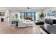 Elegant living room with hardwood floors, a white sectional, and water views at 831 Bay Point Dr, Madeira Beach, FL 33708
