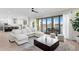 Open-concept living room with a large sectional, dark wood table, and water views at 831 Bay Point Dr, Madeira Beach, FL 33708