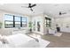 Luxurious main bedroom with water views, ceiling fan, and sitting area at 831 Bay Point Dr, Madeira Beach, FL 33708