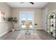 Bright office space with a glass desk, modern decor, and sliding doors leading to a balcony with outdoor views at 831 Bay Point Dr, Madeira Beach, FL 33708