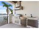 Outdoor kitchen with stainless steel appliances and views of the waterfront at 831 Bay Point Dr, Madeira Beach, FL 33708