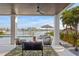 Comfortable outdoor living space featuring stylish seating, a ceiling fan, and views of the waterfront at 831 Bay Point Dr, Madeira Beach, FL 33708