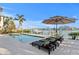 Waterfront property featuring a swimming pool, dock and lounge chairs overlooking the water at 831 Bay Point Dr, Madeira Beach, FL 33708
