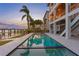 Beautiful in-ground pool next to a waterfront home with an inviting poolside lounge area at 831 Bay Point Dr, Madeira Beach, FL 33708