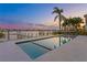 Inviting in-ground pool next to a waterfront home with lush landscaping and boat dock in view at 831 Bay Point Dr, Madeira Beach, FL 33708