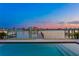Waterfront pool with view of docks and boats at twilight creates a serene and scenic backdrop at 831 Bay Point Dr, Madeira Beach, FL 33708