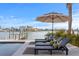 An inviting outdoor space with lounge chairs, umbrella and waterfront views at 831 Bay Point Dr, Madeira Beach, FL 33708