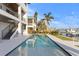 A luxurious rectangular pool is situated on the waterfront and adjacent to a modern house at 831 Bay Point Dr, Madeira Beach, FL 33708