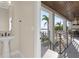 Stylish powder room with pedestal sink and views of the outdoor lounge area at 831 Bay Point Dr, Madeira Beach, FL 33708