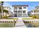 This modern house features a dock, balconies, a pool and a spacious backyard at 831 Bay Point Dr, Madeira Beach, FL 33708