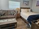 Bedroom with queen-size bed, couch, coffee table and window with blinds at 5053 N Beach Rd # 9, Englewood, FL 34223